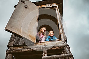Siblings discovered a hunting blind during their walk in forest, climbing up to observe beautiful spring nature photo