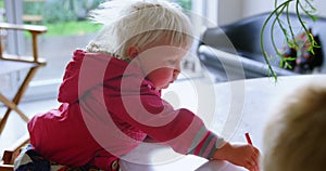 Siblings drawing with crayons on paper at home 4k