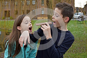 Siblings eating a bar of chocolate