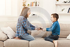Siblings fighting over remote control at home