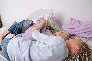 siblings having fun, laughing, boy and girl play pillow fight in messy childrens room, kids playing among the many toys