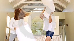 Siblings having pillow fight together