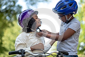 Siblings helping each other to put on a protective hemlet
