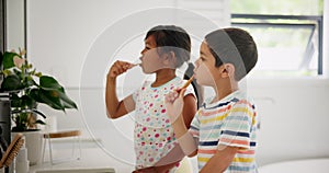 Siblings, learning or children in bathroom brushing teeth together for development in morning at family home. Boy, girl