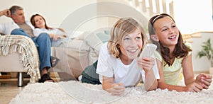 Siblings lying on the floor watching tv