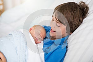 Siblings meet newborn baby in hospital