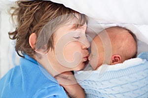Siblings meet newborn baby in hospital
