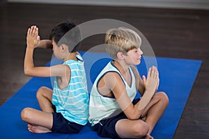 Siblings performing yoga at home