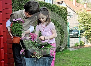 Siblings planting flowers