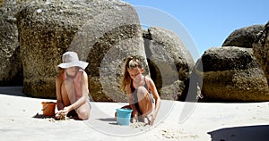 Siblings playing with sand in the beach 4k