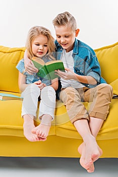siblings reading book and sitting