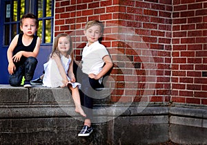 Siblings By Red Brick Wall