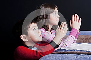 Siblings say bedtime prayers.