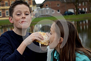 Siblings sharing a piece of pastry