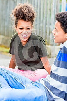 Siblings sitting on floor in yard