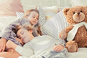 Siblings sleeping in bed