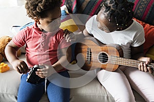 Siblings spending time together playing guitar