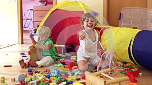 Siblings together playing in home