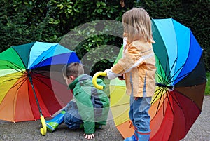 Siblings with umbrella in rainbow colors