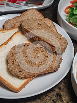 Sice of white and whole grain breads in the white plate