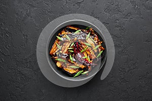 Sichuan Eggplant Stir Fry in black bowl at dark slate background. Eggplant Stir Fry is chinese cuisine dish