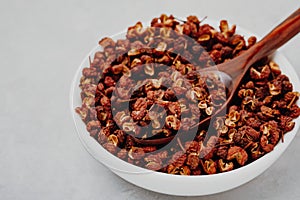 Sichuan pepper. Chinese pepper Zanthoxylum schinifolium in bowl on gray stone background close-up