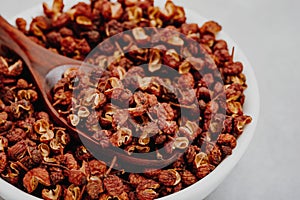 Sichuan pepper. Chinese pepper Zanthoxylum schinifolium in bowl on gray stone background close-up