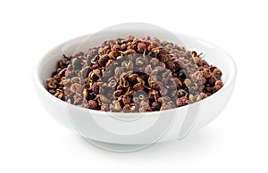 Sichuan pepper in a white bowl set against a white background