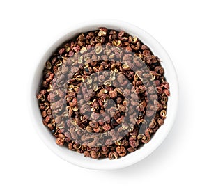 Sichuan pepper in a white bowl set against a white background