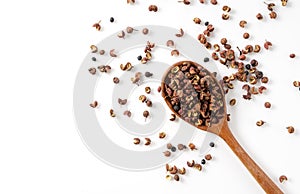 Sichuan pepper and wooden spoon set against a white background.