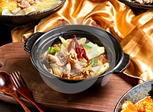 Sichuan Style Winter Noodles Claypot with fork and spoon served in dish isolated on wooden board side view of asian food