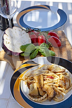 Sicilian pasta dish with traditional busiata pasta and sicilian vegetables, Viola eggplant, tomatoes served ourdoor on terrace