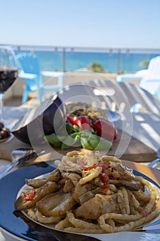 Sicilian pasta dish with traditional busiata pasta and sicilian vegetables, Viola eggplant, tomatoes served ourdoor on terrace