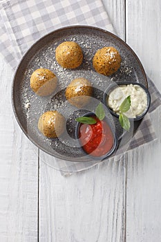Sicilian rice balls Conical shaped arancini, stuffed, coated with breadcrumbs and deep fried served with two sauces close-up in a photo