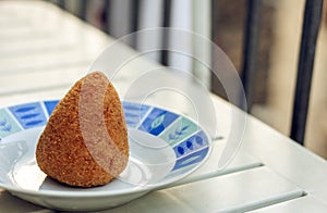 Sicilian snack, fried ball of rice arancino on a plate, tipical street food of Sicily photo