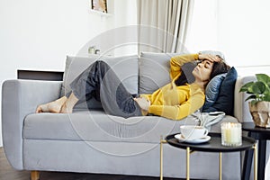 Sick afro american woman suffering from cramps resting on the sofa