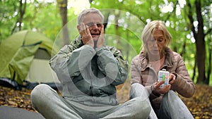Sick aged man suffering from a headache in the forest