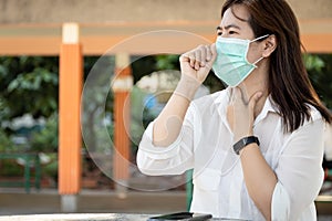 Sick asian female people with cold,flu,woman wearing hygienic mask and touch the neck with fever,cough,sore throat or Corona virus