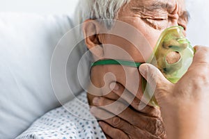 Sick asian patient in oxygen mask