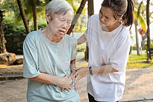 Sick asian senior woman with belly pain,elderly have severe stomach ache,left side,patient with acute pancreatitis hold hand left photo