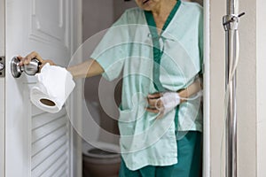 Nemocný asijský žena průjem jídlo otrávení držet tkáň úkol zahájení záchod dveře starší lidé mít břišní bolest 