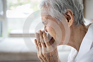 Sick asian senior woman hold paper tissue blowing running nose sneezing in handkerchief,seasonal flu,cold, ill elderly people