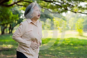 Sick Asian senior woman stomachache or Gastroenterologists, elderly have a stomach problem, acute pancreatitis cause stomach aches