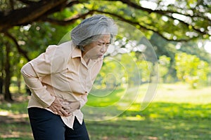 Sick Asian senior woman stomachache or Gastroenterologists, elderly have a stomach problem, acute pancreatitis cause stomach aches