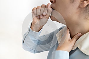 Sick asian woman with coughing into her fist and puts hand to her painful neck,sore throat,tonsillitis,symptom for cold,flu photo