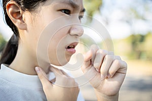 Sick asian woman has a chronic cough with tonsillitis,ill child girl touch the neck with fever,acute cough,sore throat pain