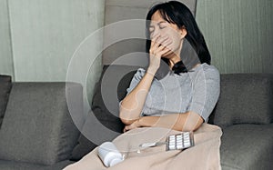 Sick asian woman having cough on sofa bed at home