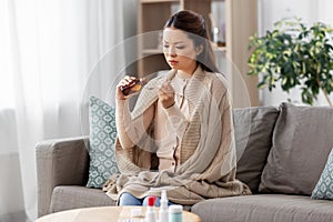 Sick asian woman taking medicine at home