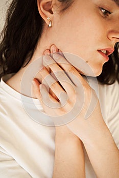 Sick attractive girl touches throat with pain. Laryngitis first symptoms throat ache. Seasonal illness medecine.