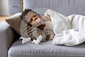 Sick black boy feeling unwell at home, coughing into fist